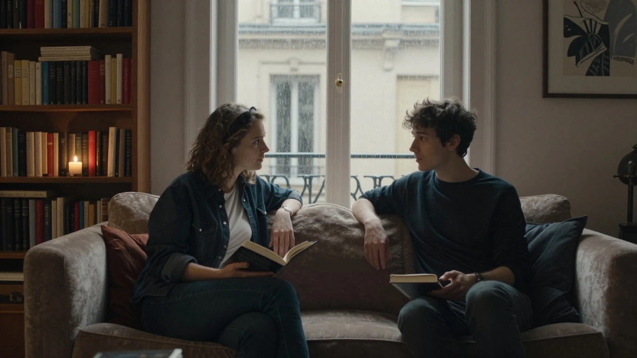 Two people sit in quiet conversation on a sofa in a softly lit Paris apartment, engaged in thoughtful dialogue with no physical contact.