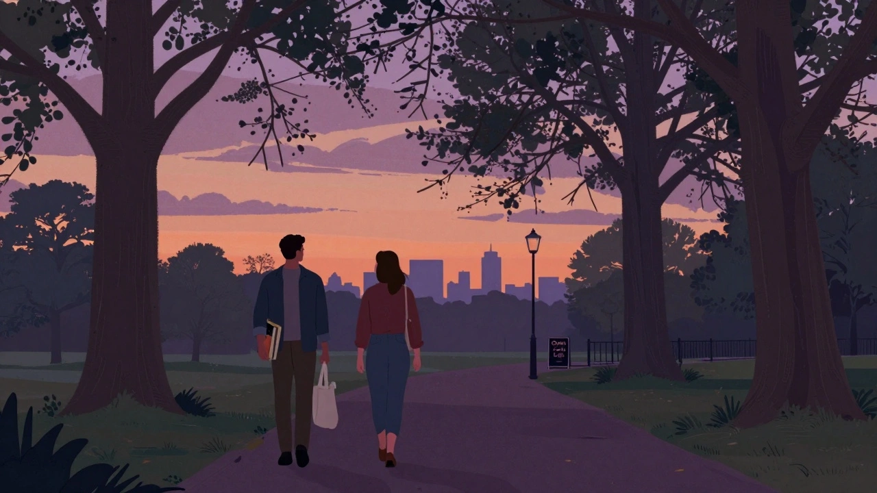 Two people walking together in Victoria Park at dusk, carrying books and enjoying the evening.