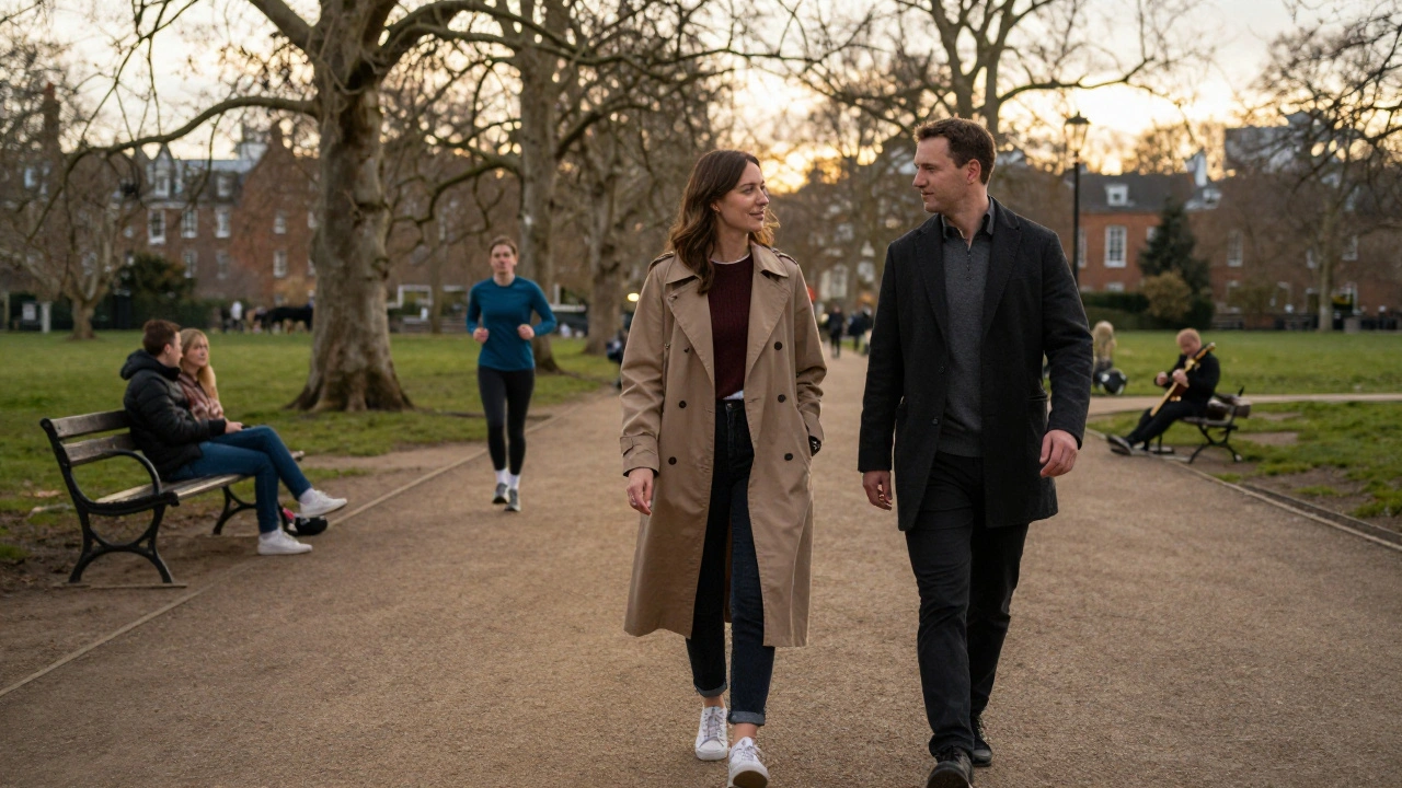 An independent escort and client walking together in Hyde Park at dusk, engaged in quiet conversation with no physical contact.